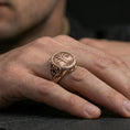 Load image into Gallery viewer, Yggdrasil ring in a rose gold plated finish on finger, raised tree of life motif with ornamental borders, lifestyle wear photo
