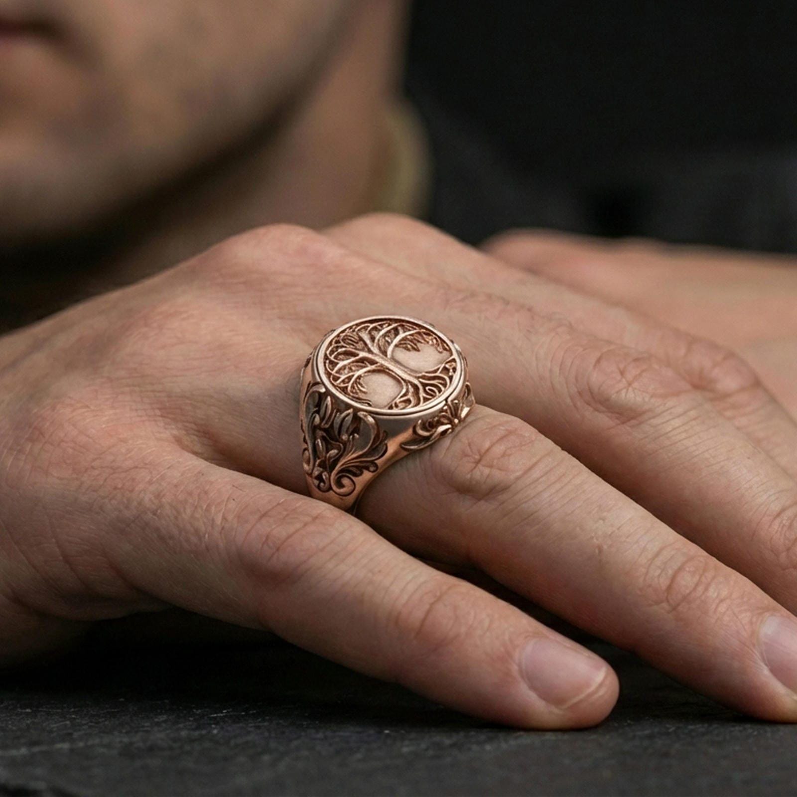 Yggdrasil ring in a rose gold plated finish on finger, raised tree of life motif with ornamental borders, lifestyle wear photo