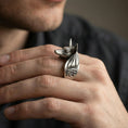Load image into Gallery viewer, Sterling silver Anubis ring in an oxidized finish worn on finger, jackal head silhouette and Eye of Horus engraving visible, lifestyle hand close-up
