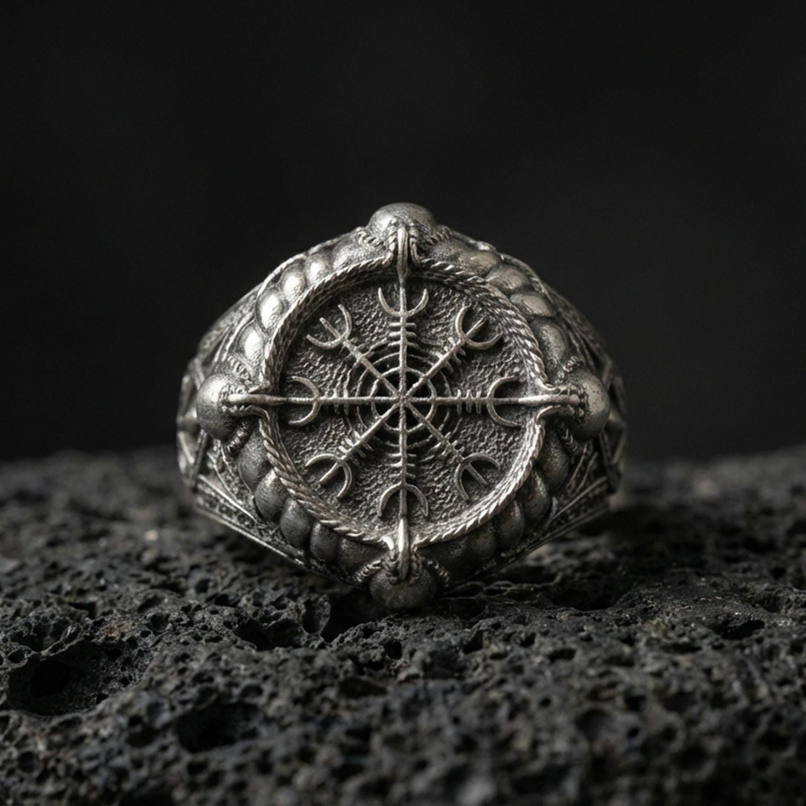 Sterling silver Vegvisir Viking compass signet ring in an oxidized finish on volcanic rock, Nordic protection symbol, macro studio shot