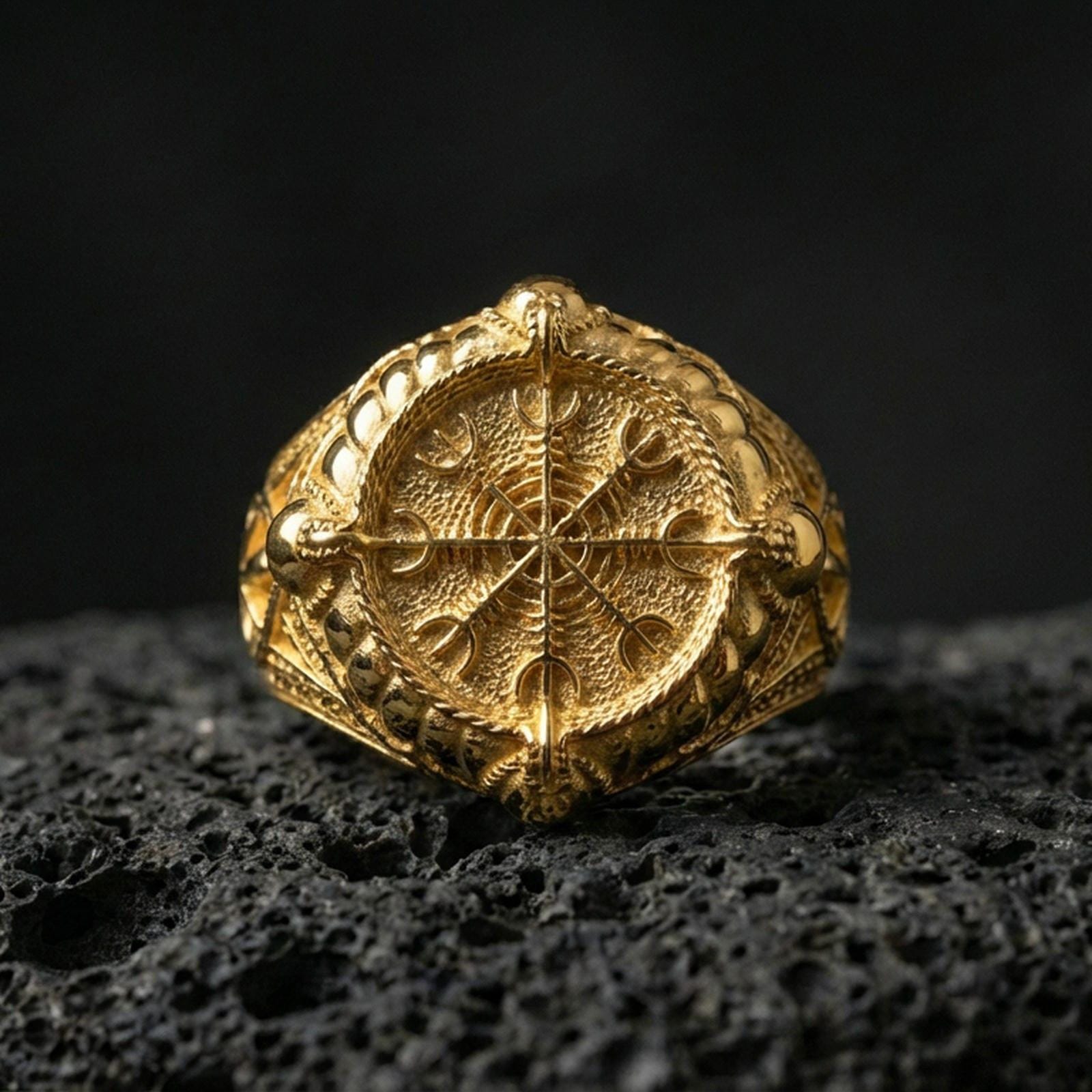 Viking Vegvisir signet ring in a gold plated finish on volcanic rock, bold Icelandic compass symbol engraving, premium macro shot
