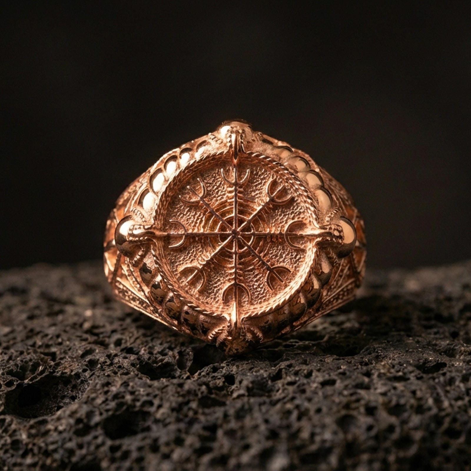 Sterling silver Vegvisir ring in a rose gold plated finish on volcanic rock, Norse navigation compass rune design, luxury close-up