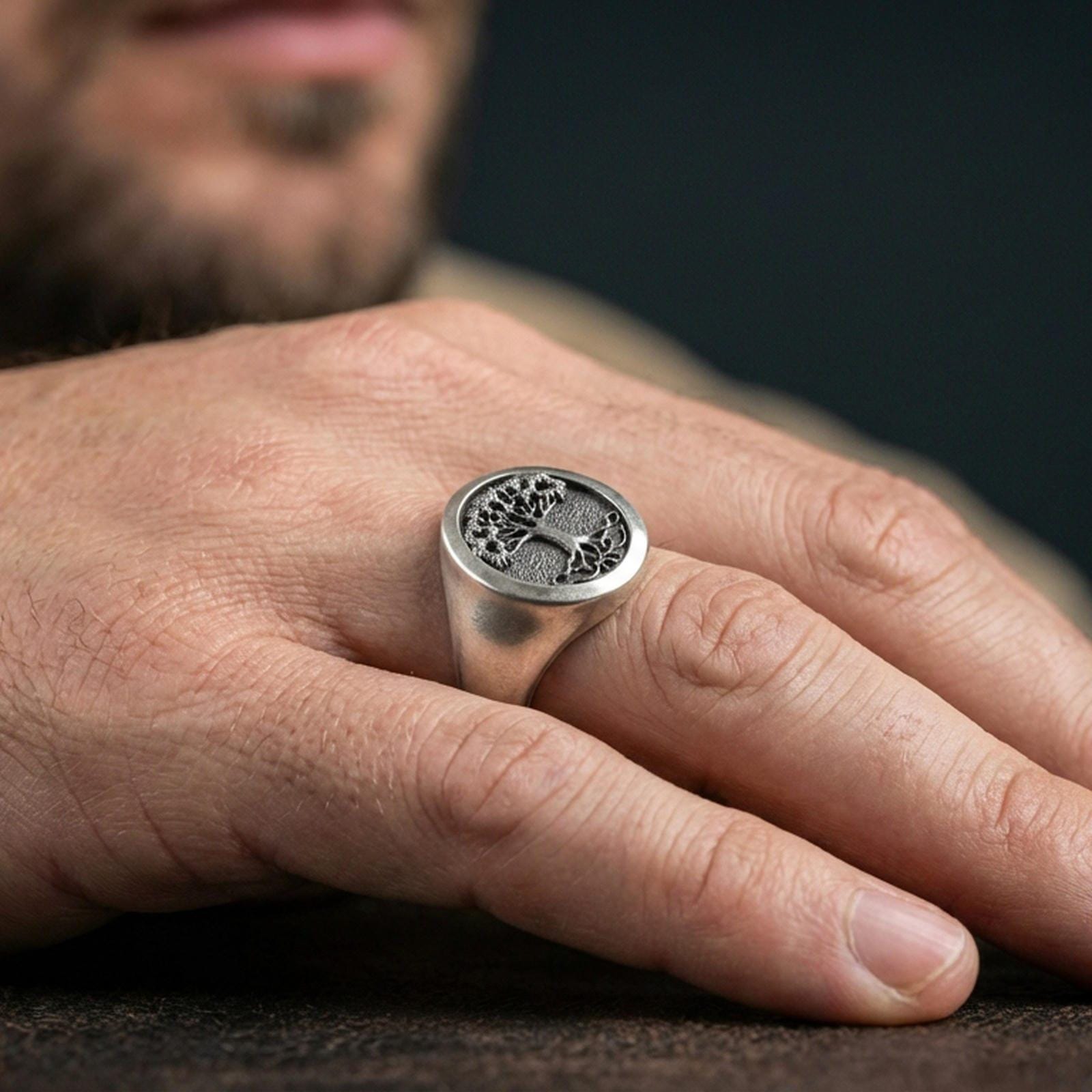 Oxidized finish Yggdrasil world tree ring on hand, signet profile and engraved face detail, minimalist lifestyle shot