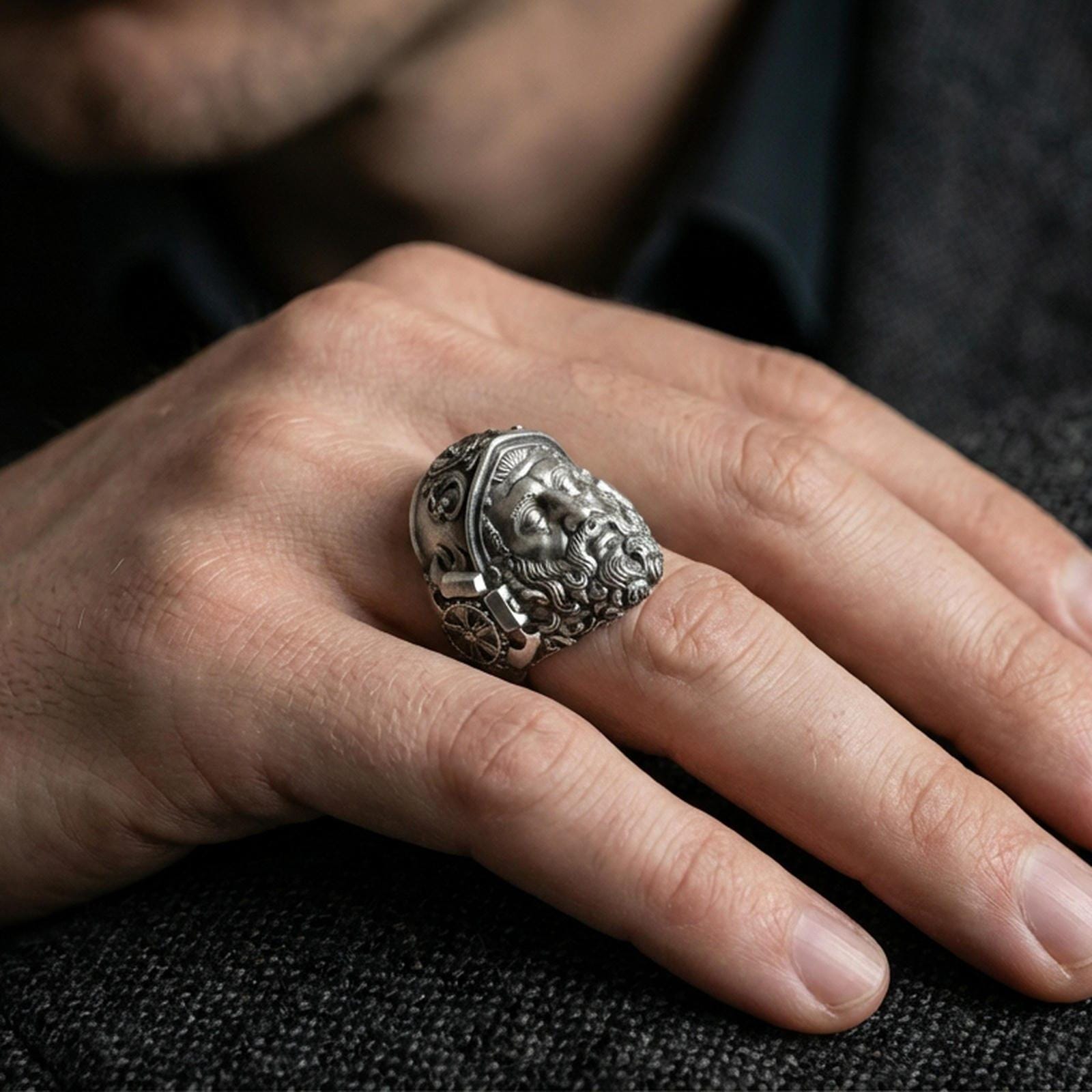Oxidized Hephaestus signet ring worn on finger, masculine mythology ring with sculpted forge god portrait and rugged depth