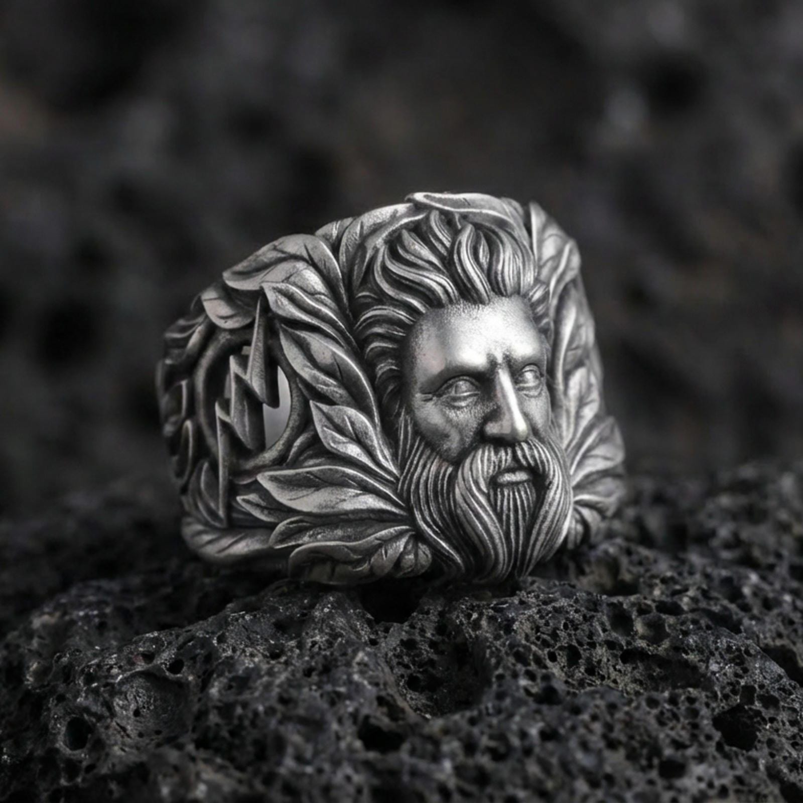 Zeus sterling silver ring with Greek god portrait and laurel details on volcanic rock, oxidized finish macro photo