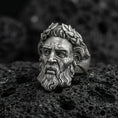 Load image into Gallery viewer, Detailed Zeus face ring in oxidized sterling silver with laurel wreath crown, macro product shot on textured volcanic rock background
