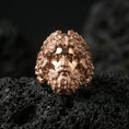 Load image into Gallery viewer, Rose gold plated Zeus head ring with sculpted mythology face and ornate hair texture, sharp close-up product photography on volcanic rock
