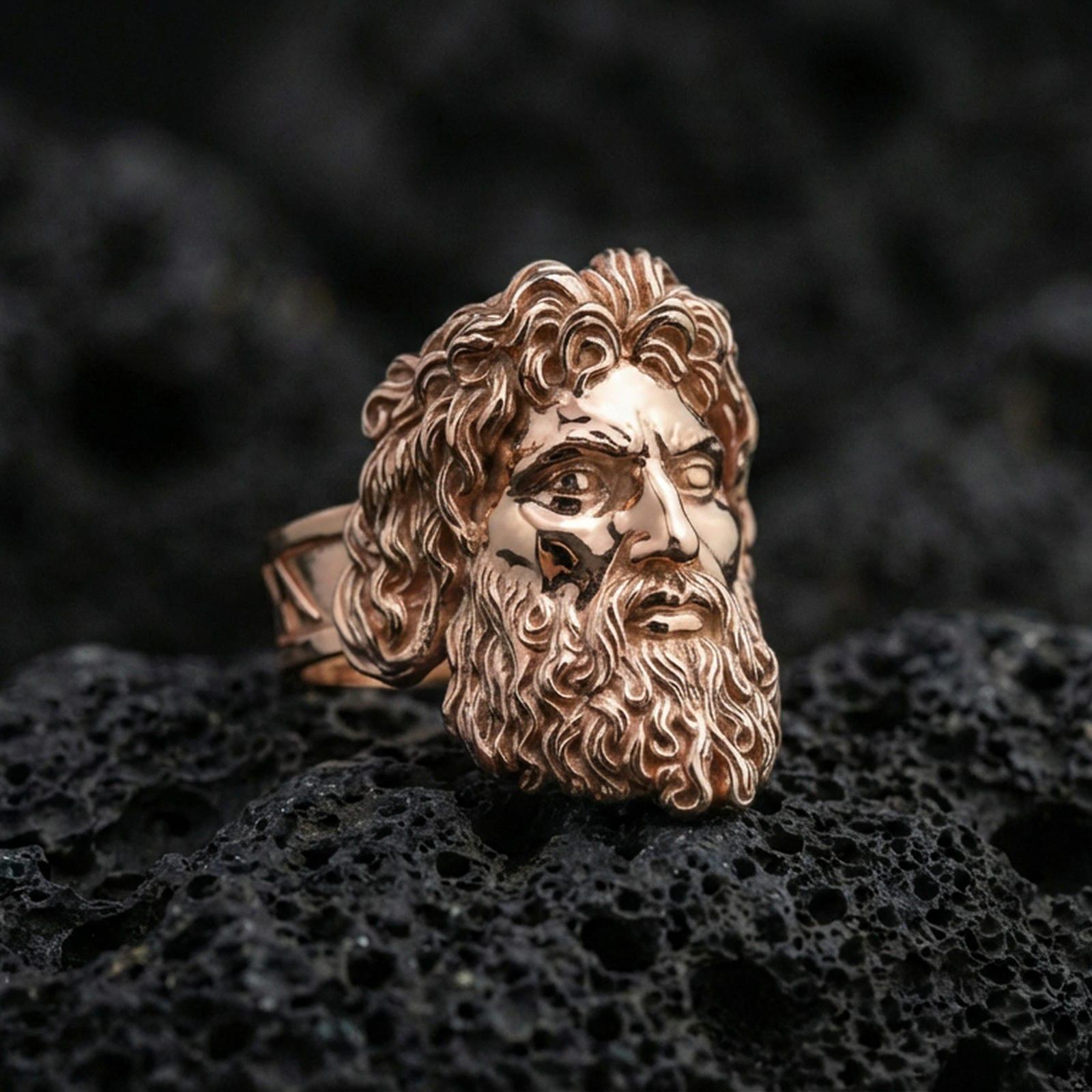Rose gold plated Zeus signet ring with expressive face and refined sculptural texture, sharp close-up product photography on volcanic rock