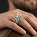 Load image into Gallery viewer, Polished silver Minotaur ring on finger highlighting detailed muscular body and double axe relief, clean lifestyle wear photo
