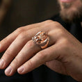 Load image into Gallery viewer, Rose gold plated griffin signet ring on finger featuring seated winged guardian beast, refined fantasy jewelry lifestyle wear shot
