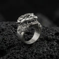 Load image into Gallery viewer, Detailed Foo Dog ring crafted in oxidized sterling silver, fierce Chinese guardian lion head with ornate swirl engravings, macro product shot on textured volcanic rock background
