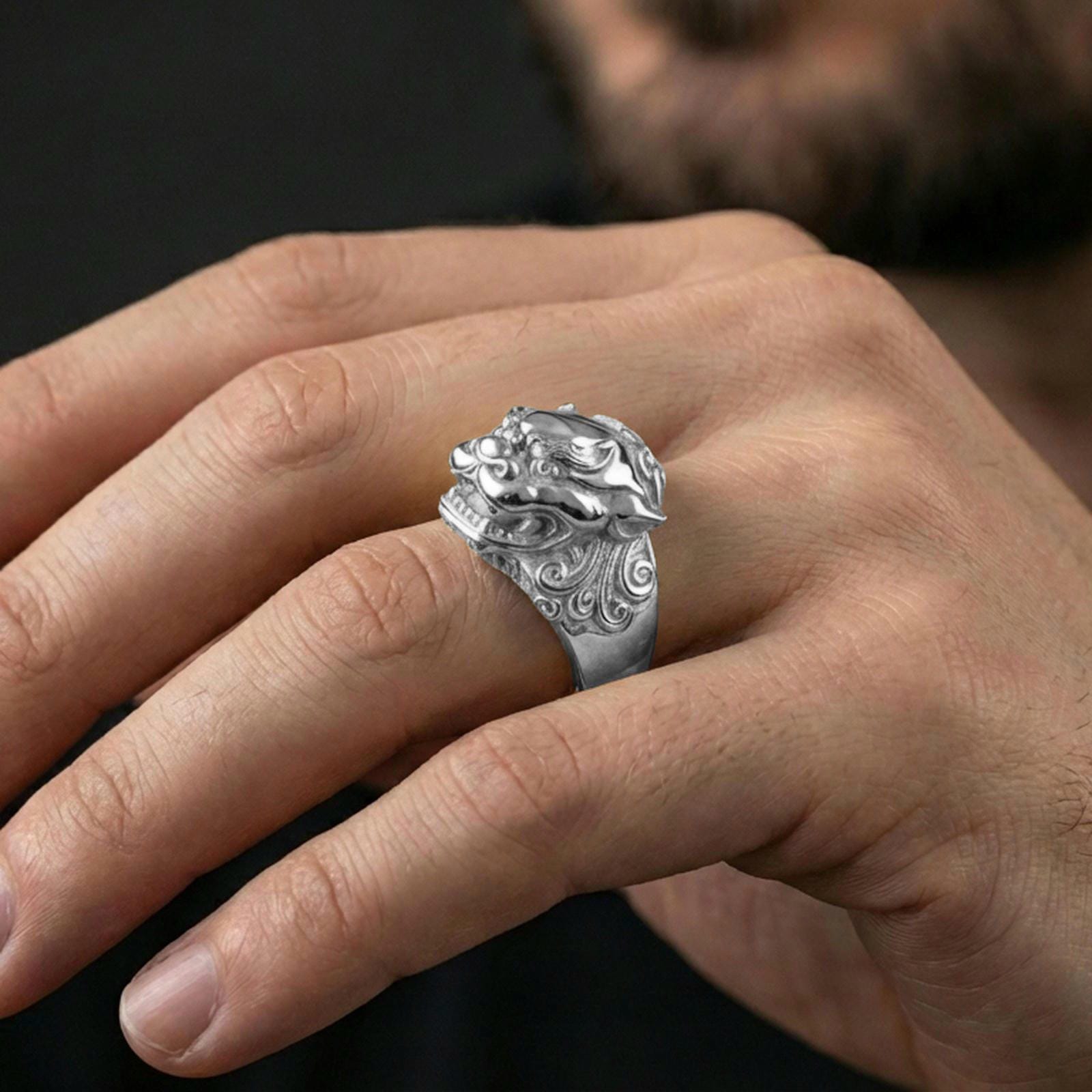 Polished silver Foo Dog ring on finger highlighting detailed lion face and engraved patterns, clean lifestyle wear photo