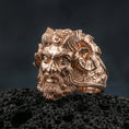 Load image into Gallery viewer, Rose gold plated Czernobog ring showcasing ornate Slavic god face and horned crown motif, sharp close-up product photography on volcanic rock

