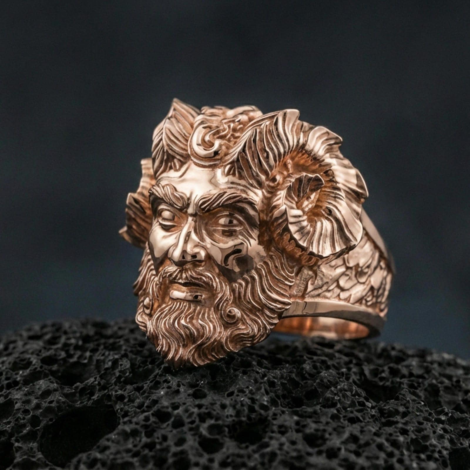 Rose gold plated Czernobog ring showcasing ornate Slavic god face and horned crown motif, sharp close-up product photography on volcanic rock