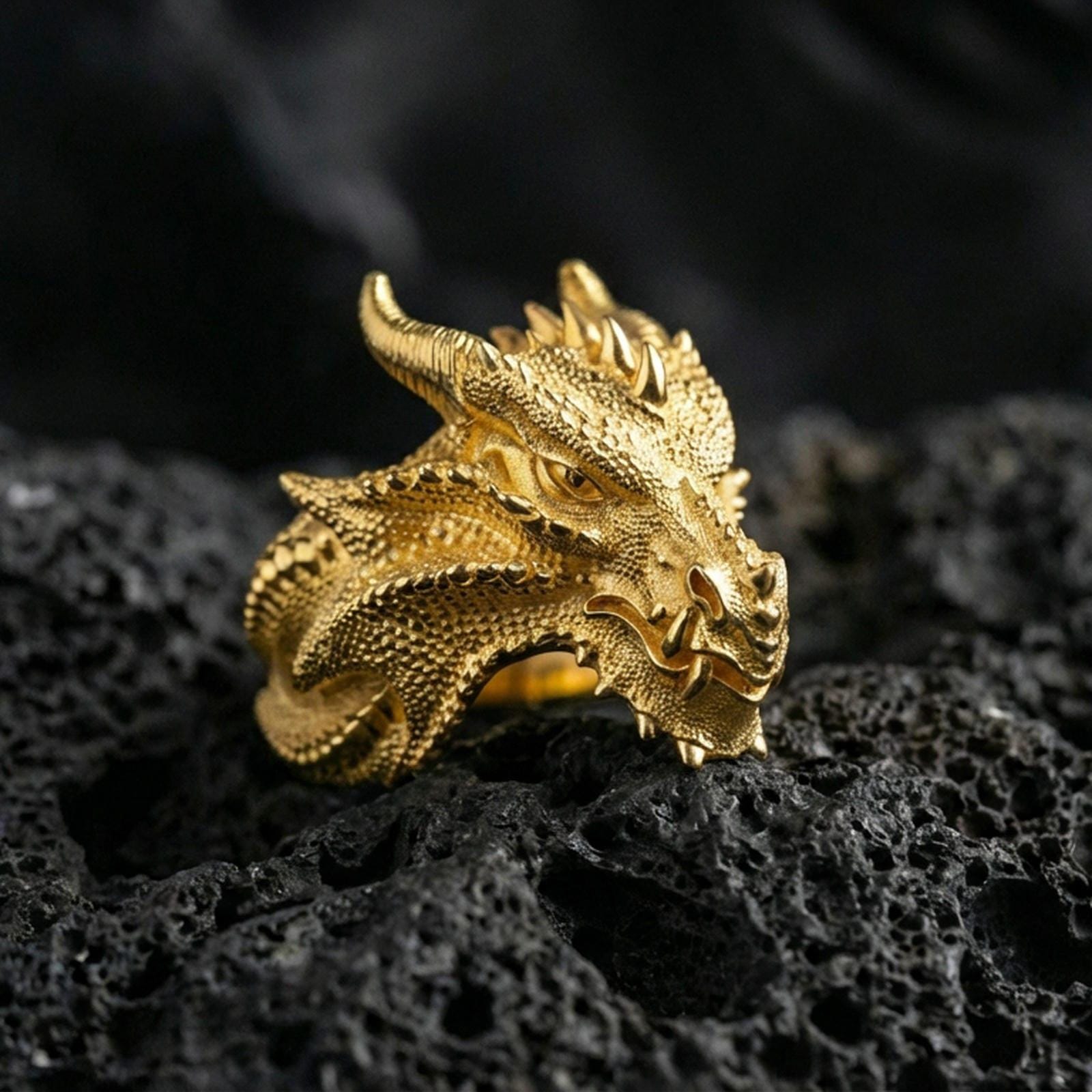Gold plated dragon wyrm statement ring with high-relief scales and fierce dragon head design, premium studio macro on black volcanic rock surface