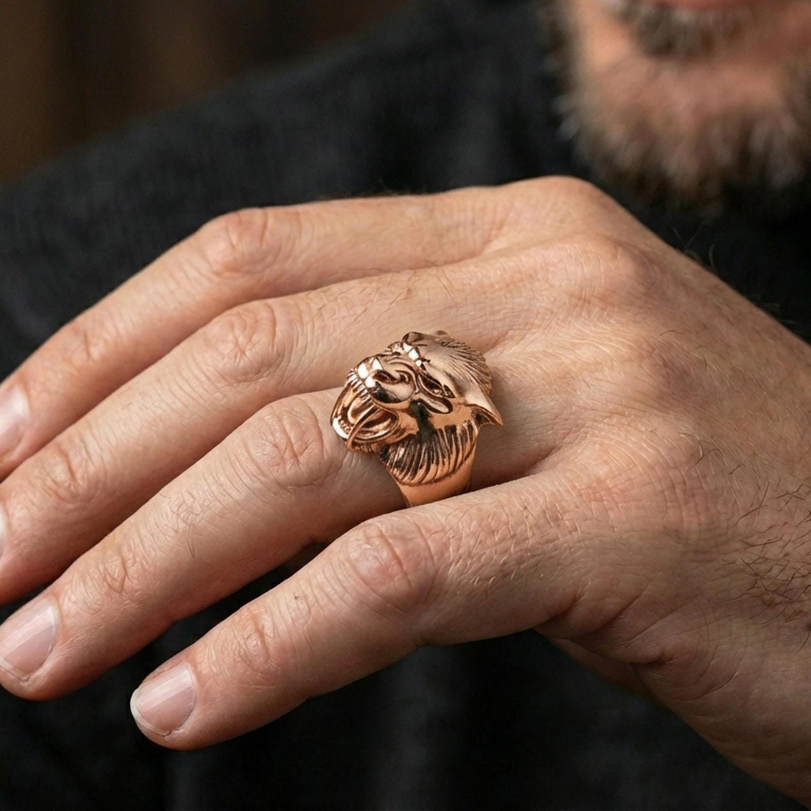Rose gold plated werewolf head ring on finger featuring snarling wolf face and sharp fang detail, refined fantasy jewelry lifestyle wear shot