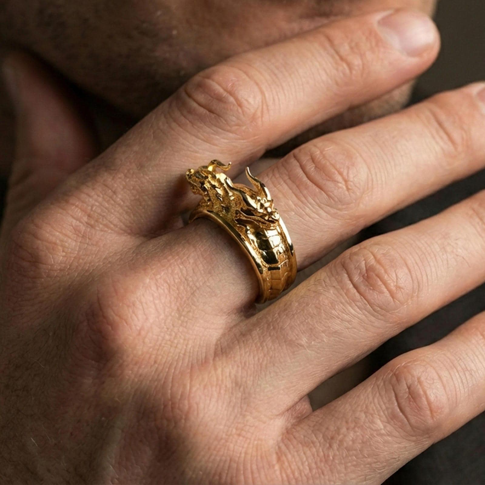 Gold plated twin dragons ring worn on finger, statement fantasy jewelry inspired by mythic dragons and power symbolism, premium lifestyle close-up