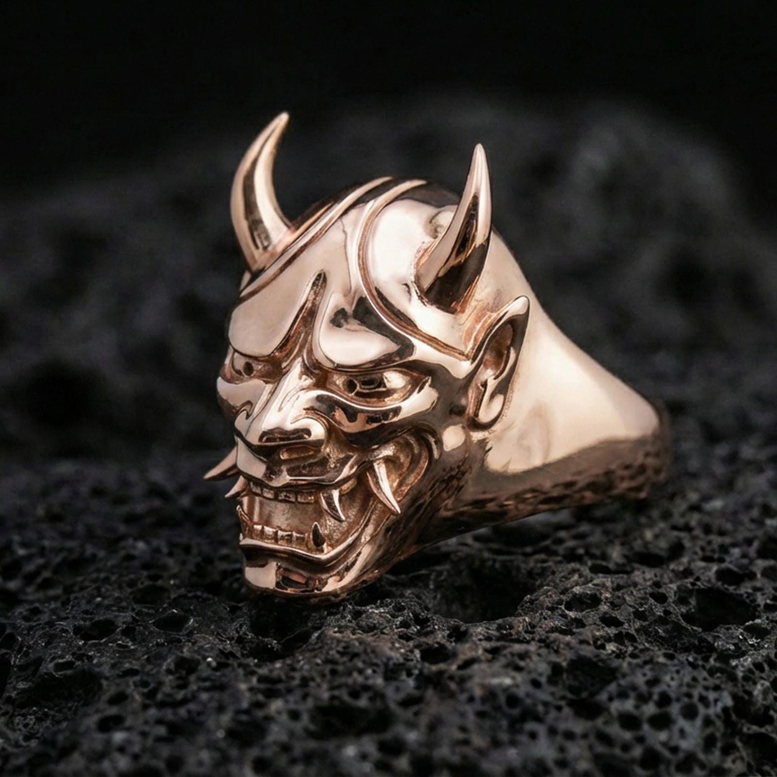 Rose gold plated Oni mask signet ring on black volcanic stone, Japanese Oni demon face ring, bold gothic signet look, high-detail carving