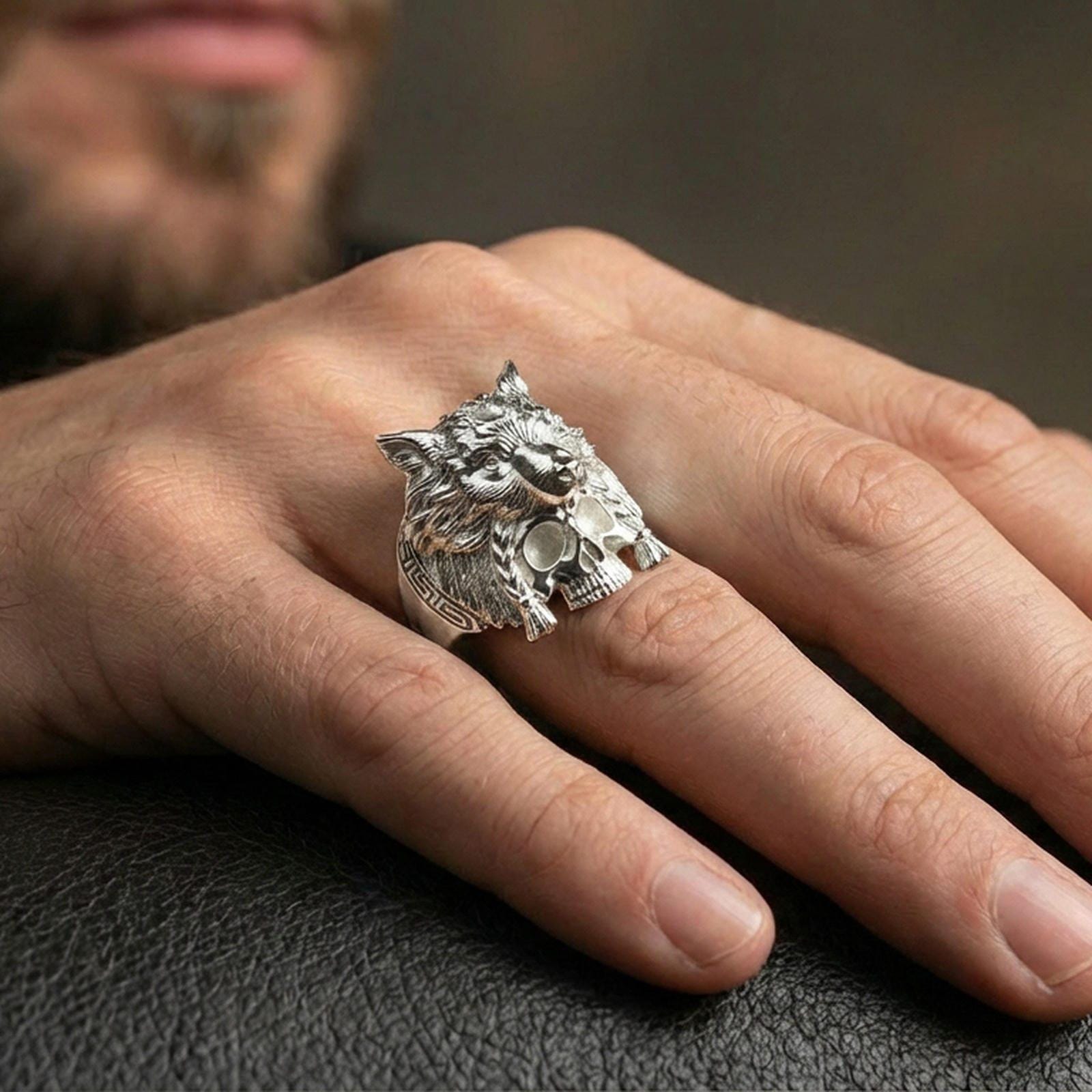 Polished sterling silver wolf headdress skull ring on a human finger, highly detailed wolf head and skull design, statement signet