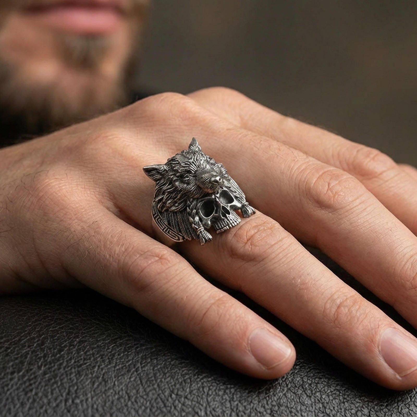 Oxidized sterling silver wolf headdress skull ring on a human finger, tribal wolf warrior ring with skull motif, dark gothic styling
