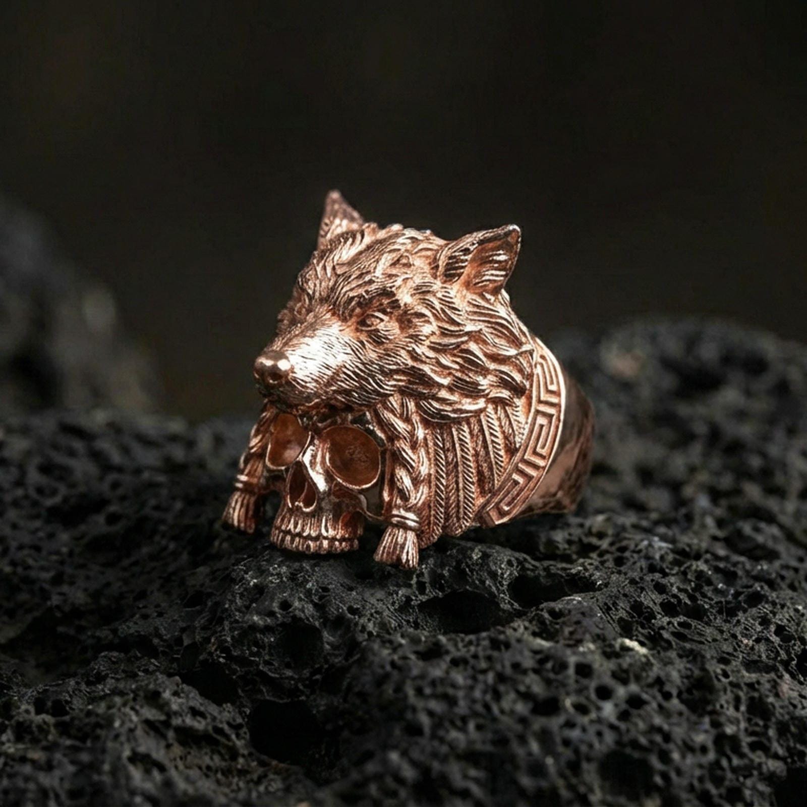 Rose gold plated wolf headdress skull ring on black volcanic stone, wolf head and skull signet ring, dramatic fantasy aesthetic