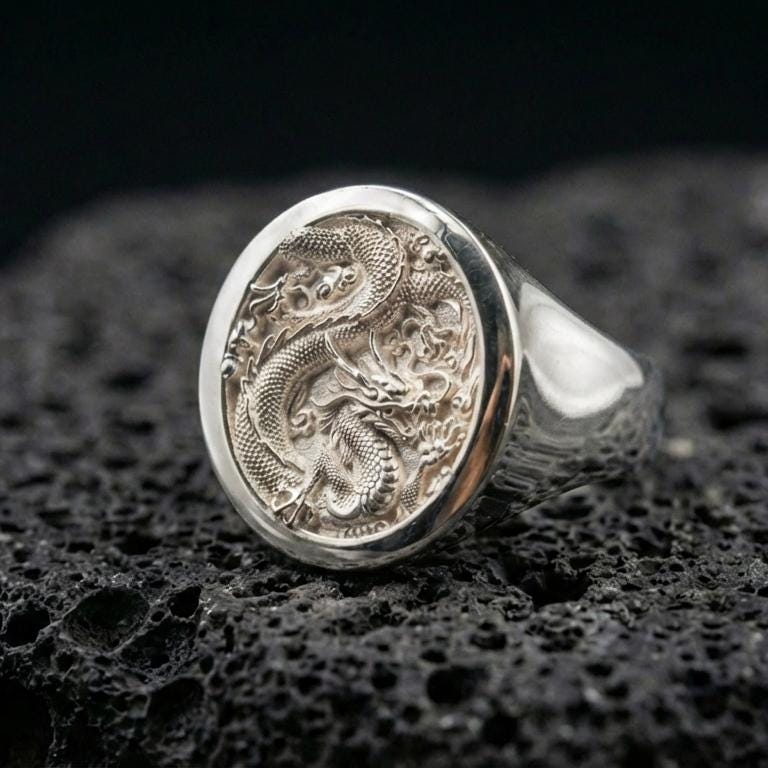 Polished sterling silver Chinese dragon signet ring on black volcanic stone, detailed scaled dragon carving, bold unisex statement ring
