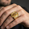 Load image into Gallery viewer, Gold plated skull signet ring worn on a human finger, gothic brickwork motif, bold fashion ring

