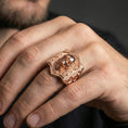 Load image into Gallery viewer, Rose gold plated skull signet ring on a human finger, skull emblem signet, dark aesthetic accessory
