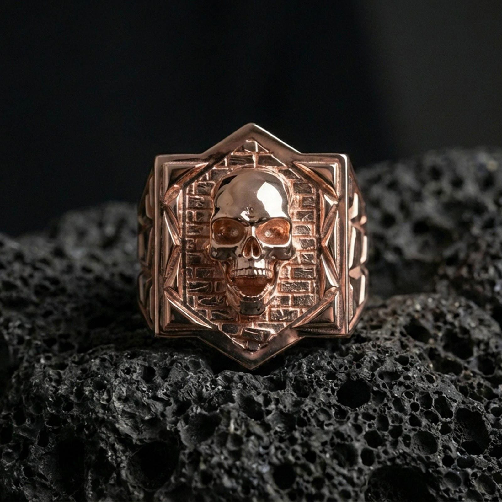 Rose gold plated skull signet ring on black volcanic stone, sculpted skull emblem, vintage gothic style