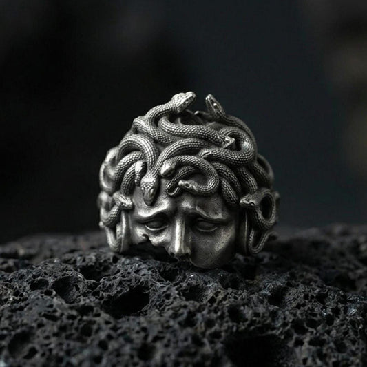 Oxidized sterling silver Medusa head ring on black volcanic stone, snake hair gorgon face relief, Greek mythology signet ring