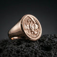 Load image into Gallery viewer, Rose gold plated dragon signet ring on black volcanic stone, detailed dragon carving, symbolic medieval jewelry
