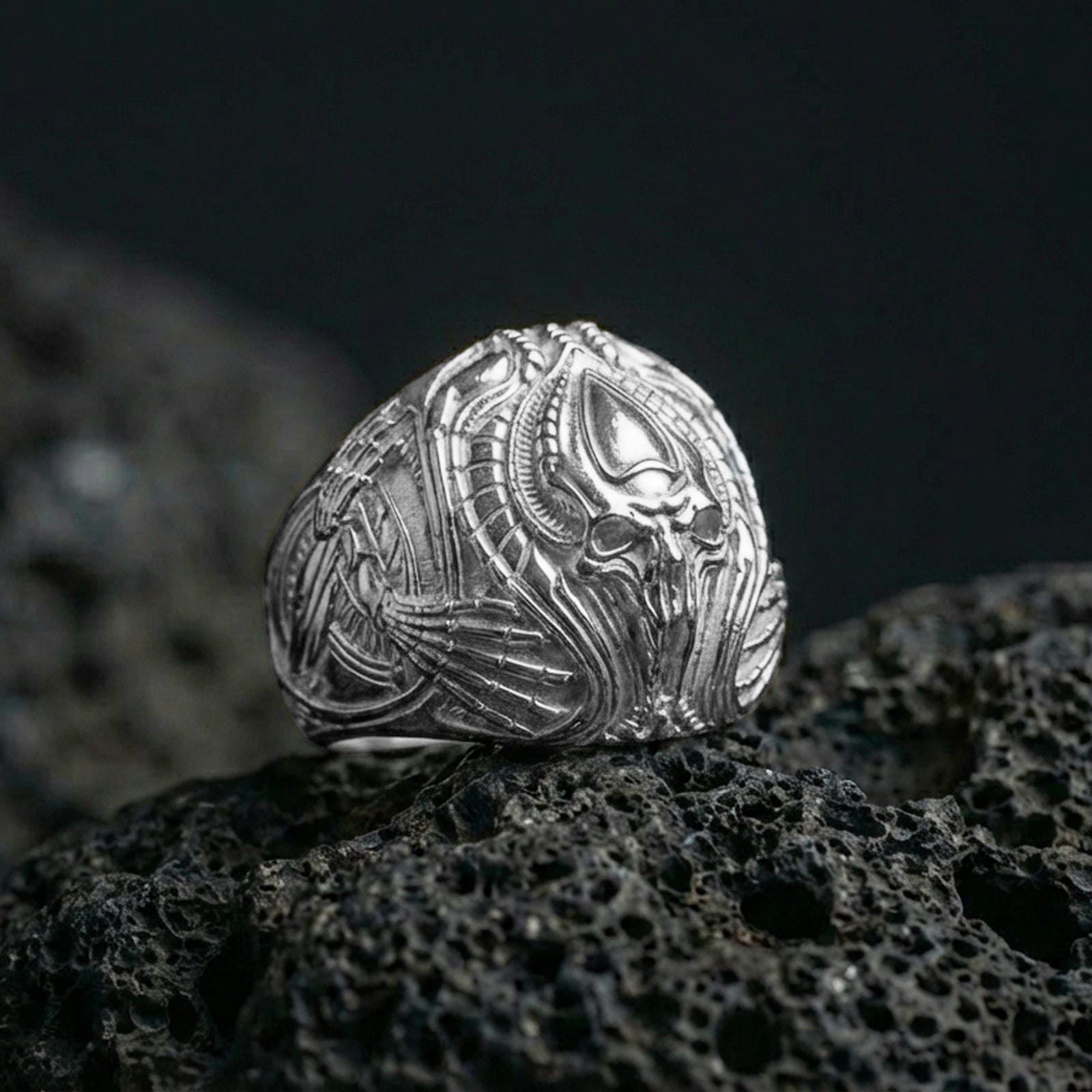 Polished sterling silver alien skull ring on black volcanic stone, biomechanical sci-fi design, gothic statement ring