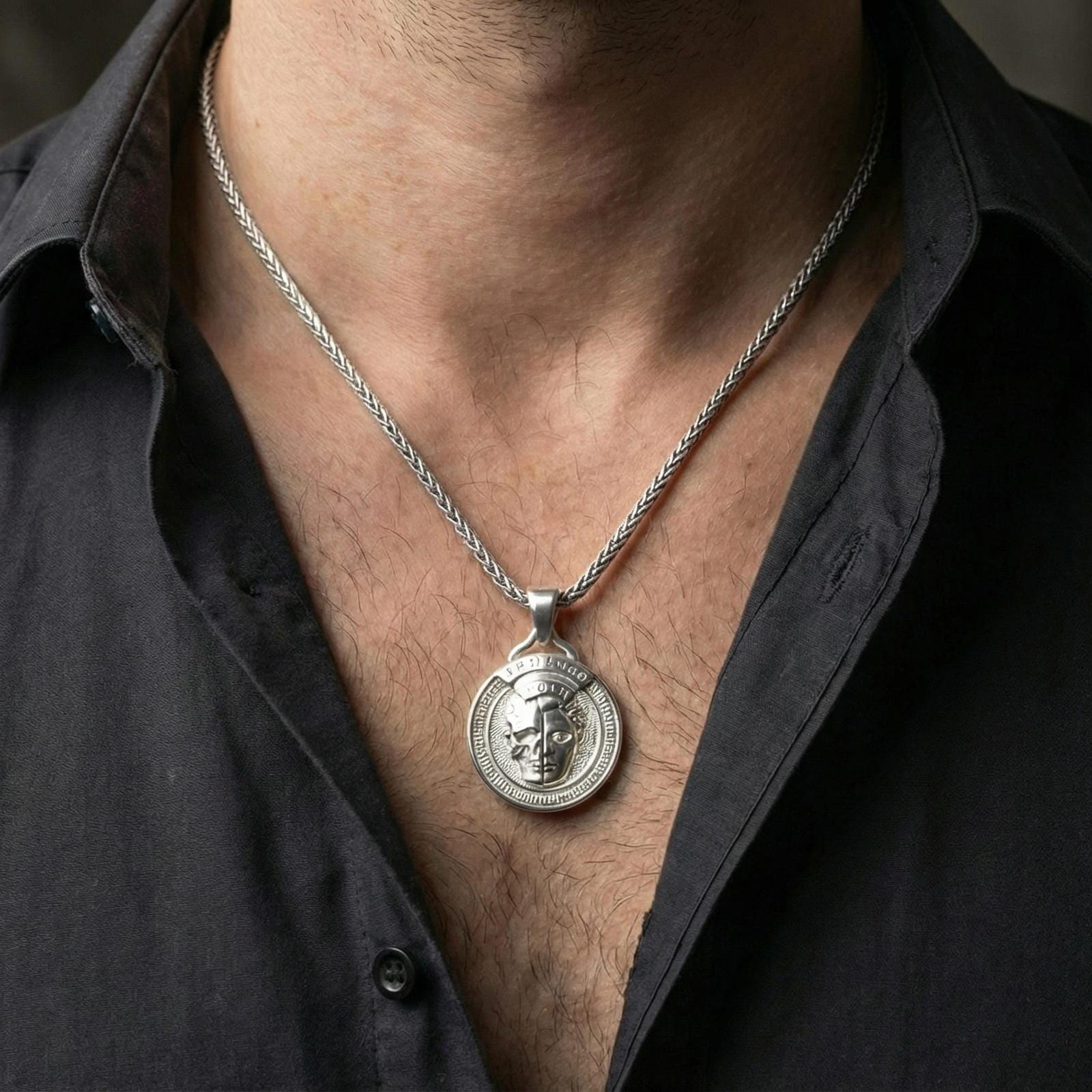 Polished silver memento mori medallion necklace worn on neck, close lifestyle crop, crisp engraving and relief visibility