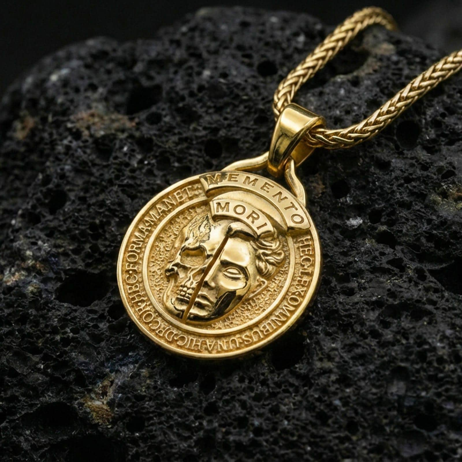 Gold plated memento mori pendant on matte volcanic stone backdrop, dual-face skull motif, luxury high-contrast lighting