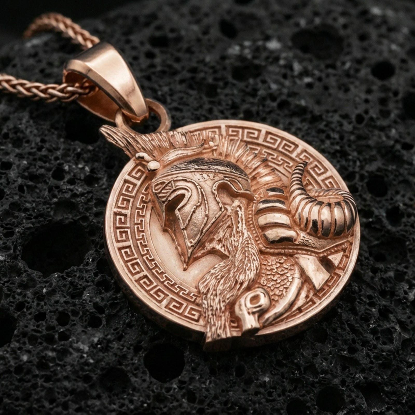 Rose gold plated Norse warrior pendant on matte volcanic stone, intricate warrior helmet relief with decorative frame, sharp macro focus
