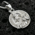 Load image into Gallery viewer, Polished silver Norse warrior medallion necklace on dark volcanic stone, detailed helmet and beard engraving, premium close-up composition
