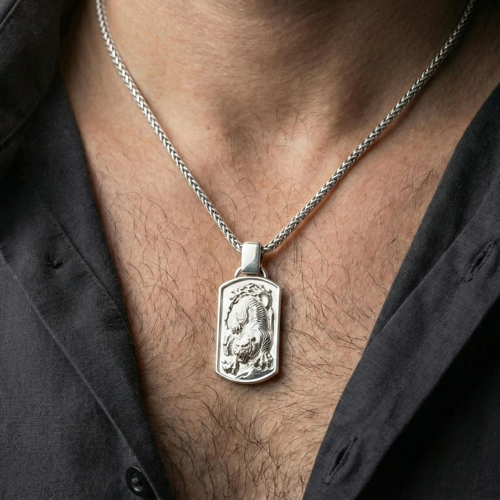 Polished silver zodiac tiger pendant necklace worn on neck, close lifestyle crop, clear tiger engraving and frame detail