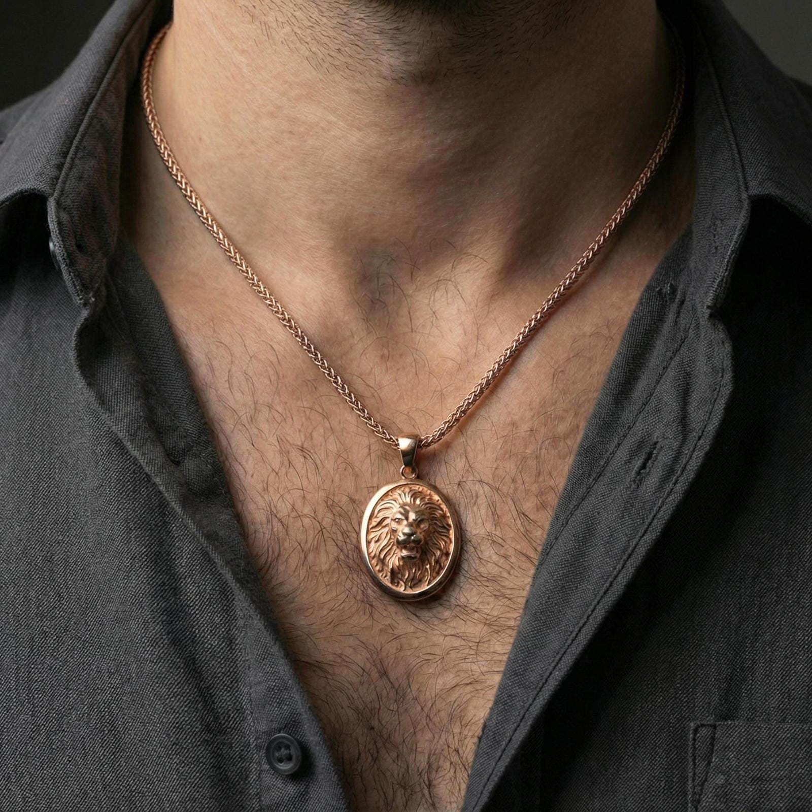 Rose gold plated lion oval pendant worn on neck, detailed lion face relief, clean lifestyle framing with dark shirt contrast