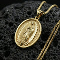 Load image into Gallery viewer, Gold plated Our Lady of Guadalupe pendant on porous volcanic rock backdrop, oval devotional medallion with detailed relief, high-contrast lighting
