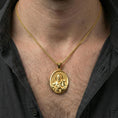 Load image into Gallery viewer, Gold plated Saint Francis pendant necklace worn on neck, premium lifestyle composition, devotional oval medallion centerpiece
