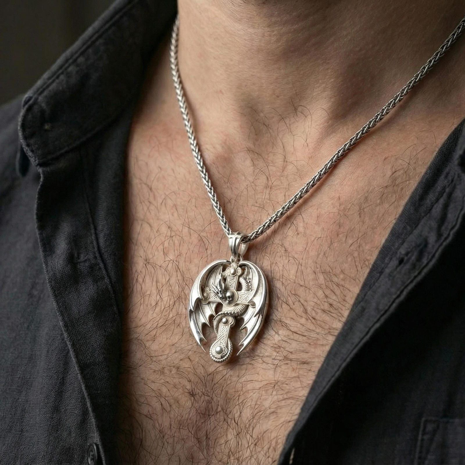 Polished silver winged dragon cross necklace worn on neck, close lifestyle crop, clear cross engraving and dragon wing details