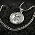 Load image into Gallery viewer, Polished silver Mortal Kombat dragon medallion necklace on textured volcanic stone, crisp circular border and engraved background, close-up shot
