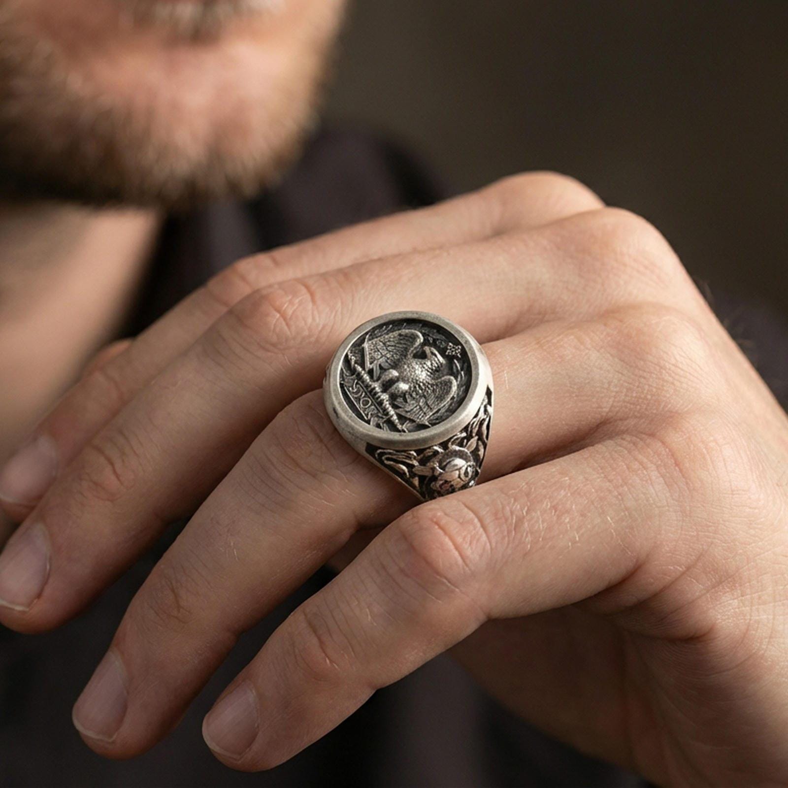 Oxidized sterling silver SPQR signet ring worn on a finger, close-up highlighting the roman eagle coin face and inscription