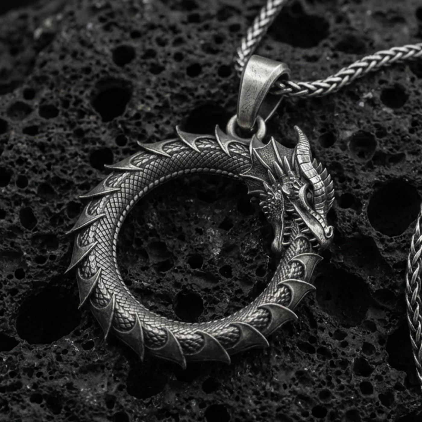 Oxidized sterling silver ouroboros dragon pendant on volcanic rock, tail-devourer eternity symbol necklace, macro close-up