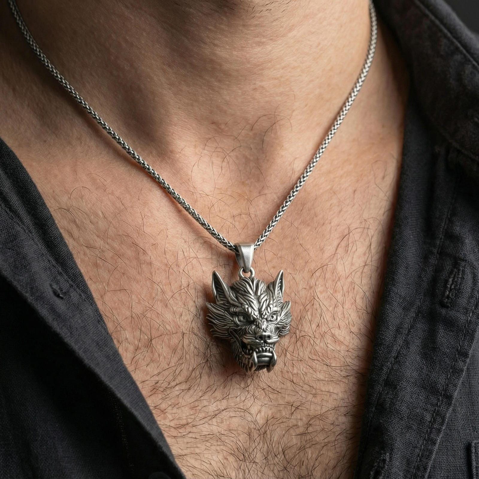 Oxidized sterling silver Chinese dragon head pendant worn on neck, mythical dragon charm necklace on braided chain, lifestyle close-up