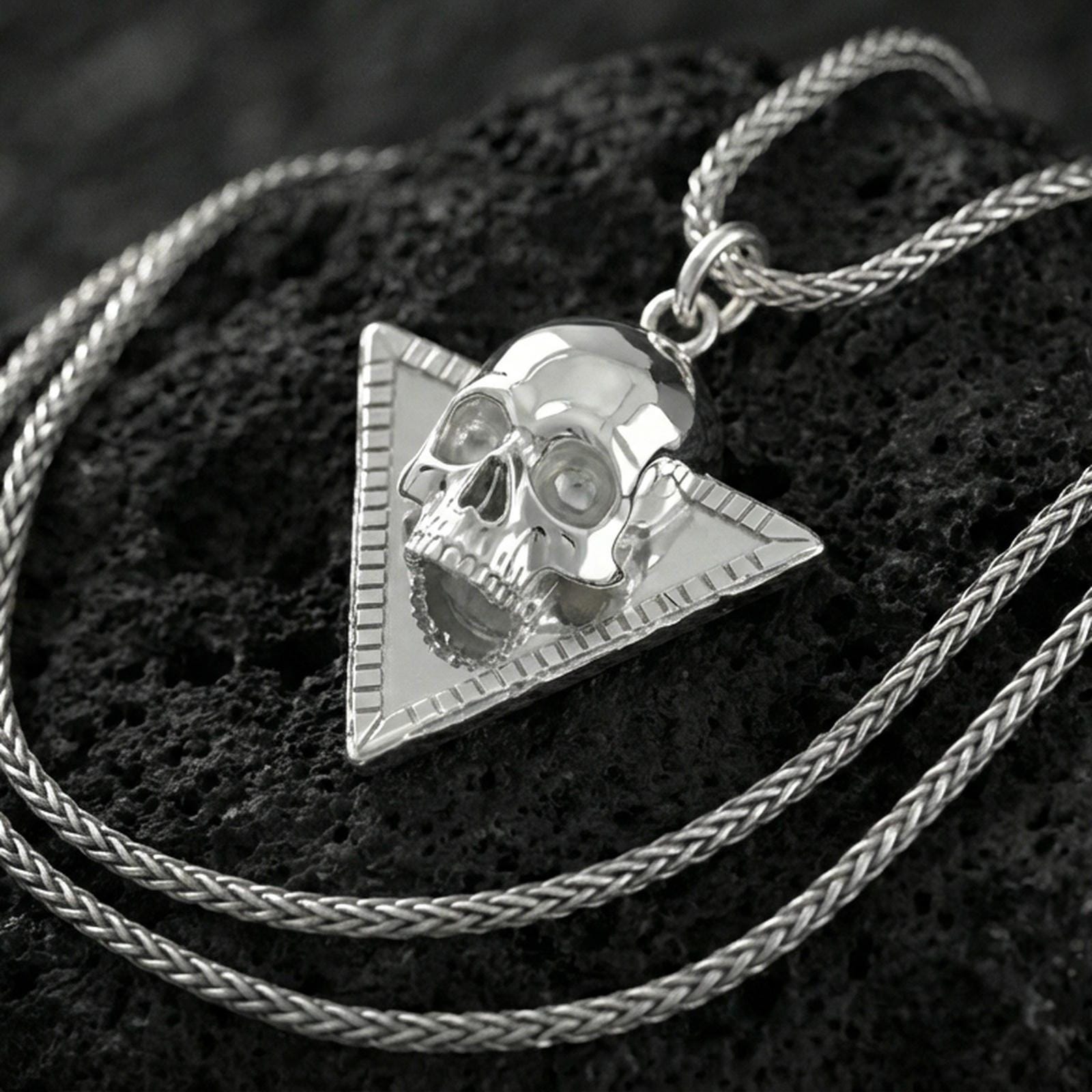 Polished silver Absolute’s talisman skull necklace on porous volcanic stone, BG3 inspired pendant, detailed studio shot