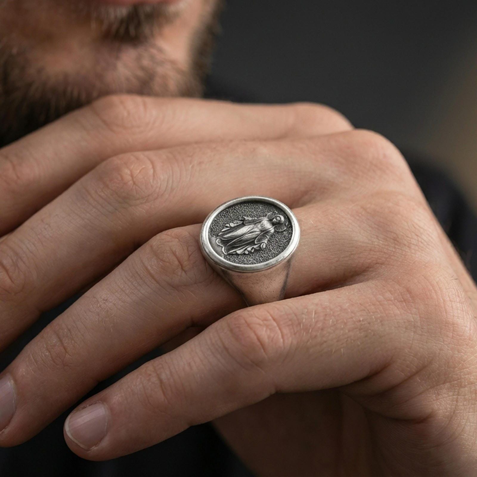 Oxidized sterling silver Virgin Mary signet ring worn on finger, oval Catholic medal ring, lifestyle close-up