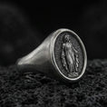 Load image into Gallery viewer, Oxidized sterling silver Virgin Mary signet ring on volcanic rock, oval religious medal face, macro product photo
