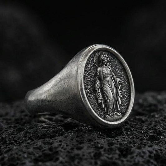 Oxidized sterling silver Virgin Mary signet ring on volcanic rock, oval religious medal face, macro product photo
