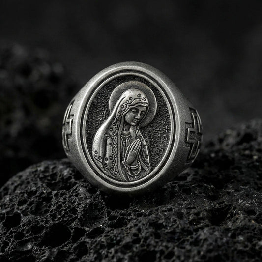 Oxidized sterling silver Our Lady of Guadalupe signet ring on volcanic rock, oval Virgin Mary relief, macro close-up